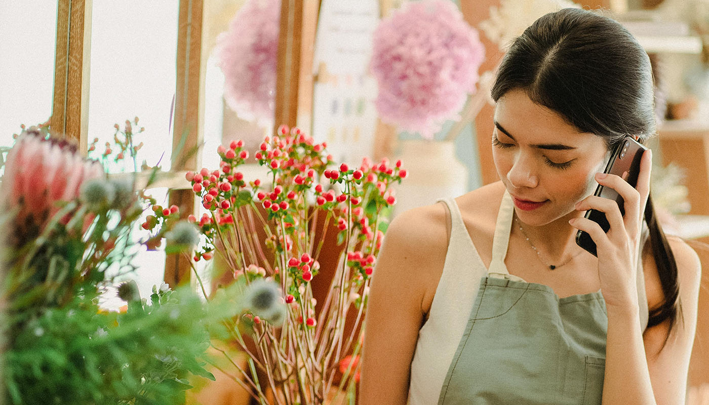 Flower shop owner talking on the phone.