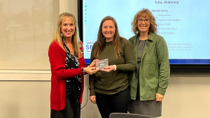 Three people receiving an award.