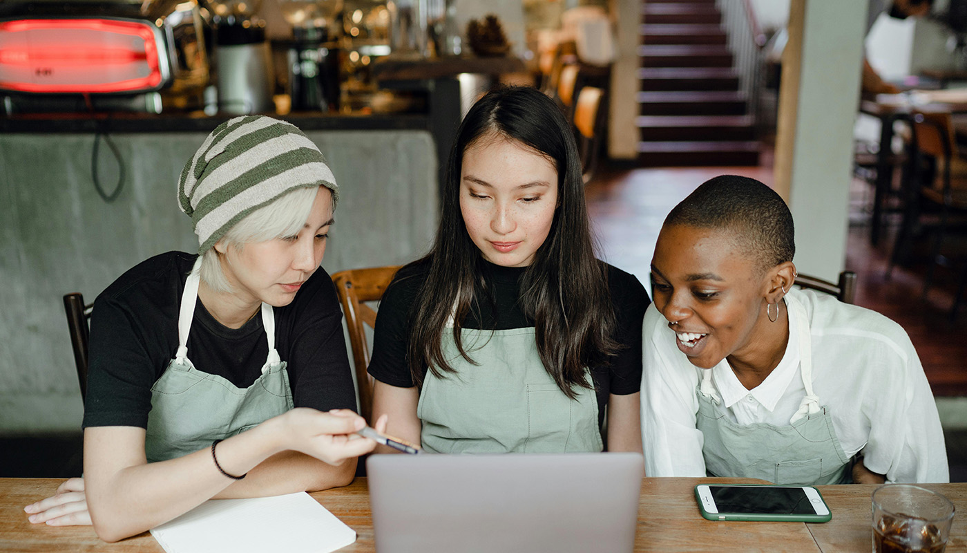 Three women at their coffee shop discussing business.