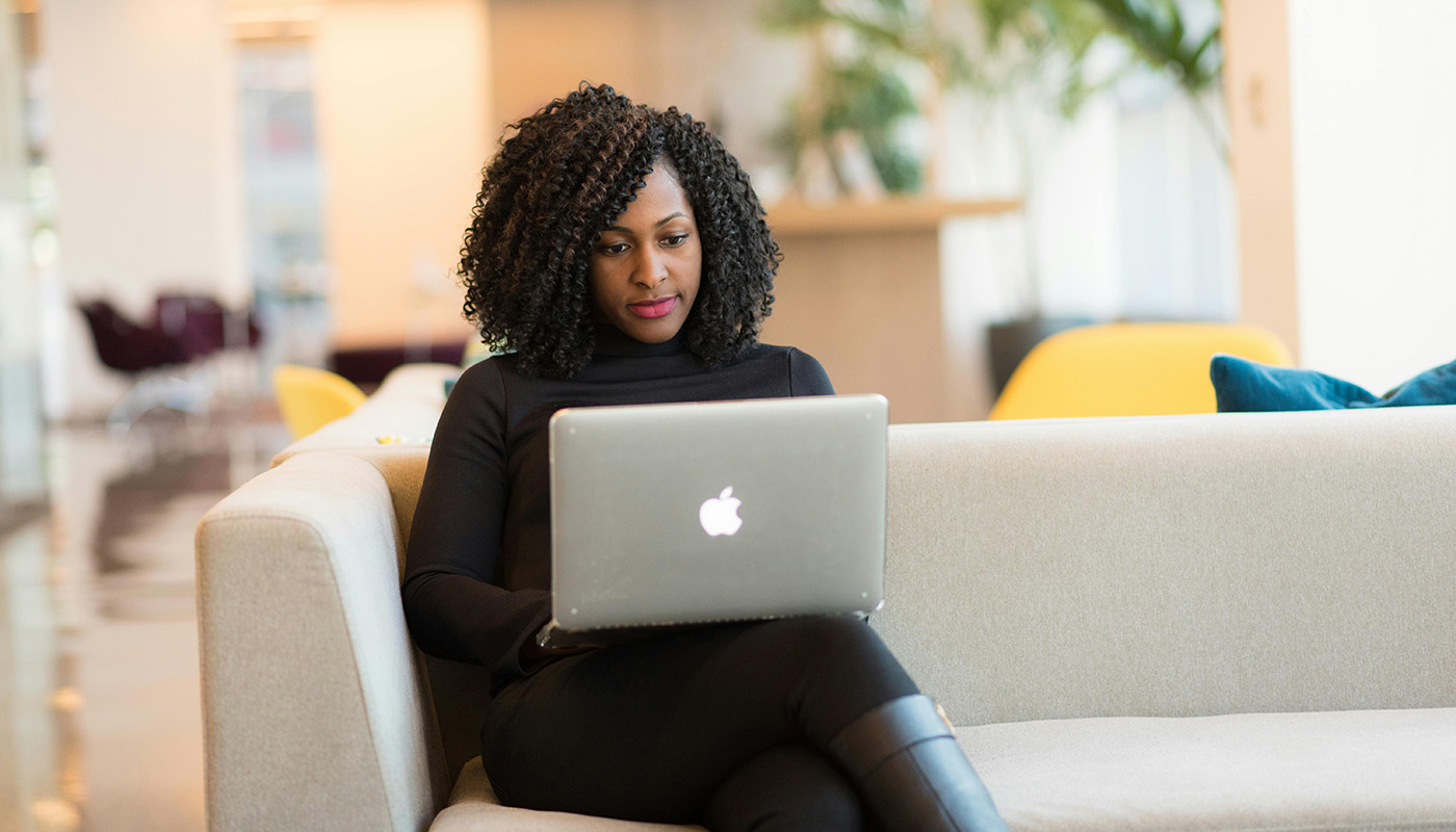 Woman working on her website visibility on a laptop in an indoor, modern setting.