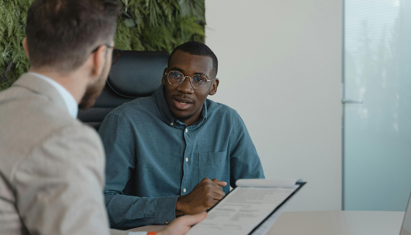 Two men discussing insurance options and details.