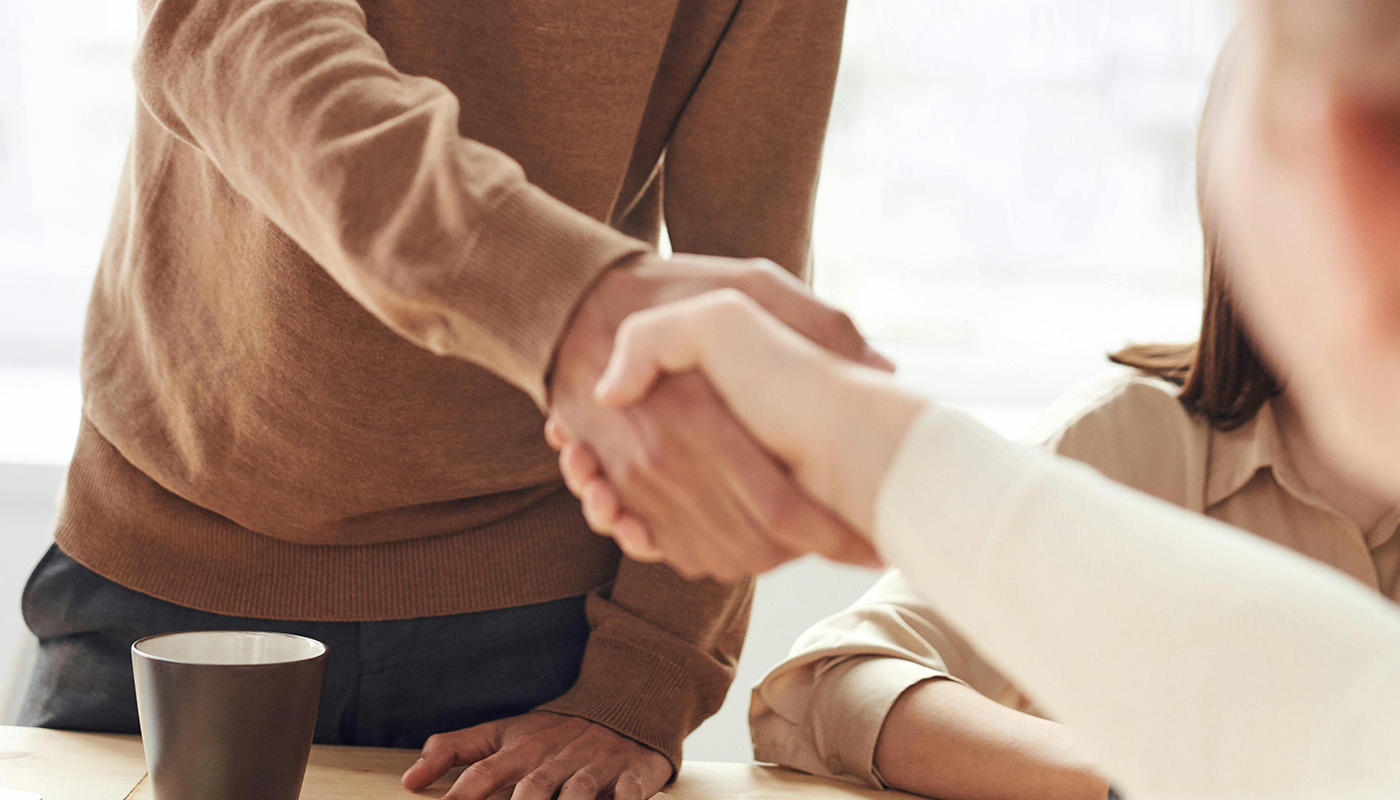 Two people shaking hands after discussing taxes.